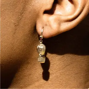 A person wearing earrings with one of them hanging from the ear.