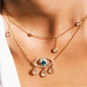 A woman wearing a necklace with an eye and hand design.