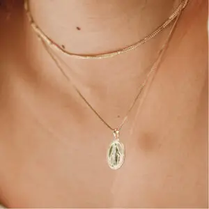 A woman wearing a necklace with a cross on it.