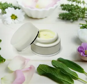 A white container with a cream on top of it.