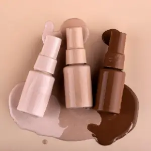 Three different bottles of makeup on a table.