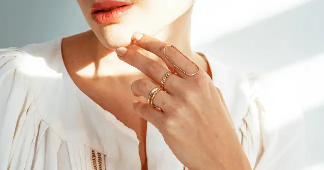 A woman with her hand on the side of her face.