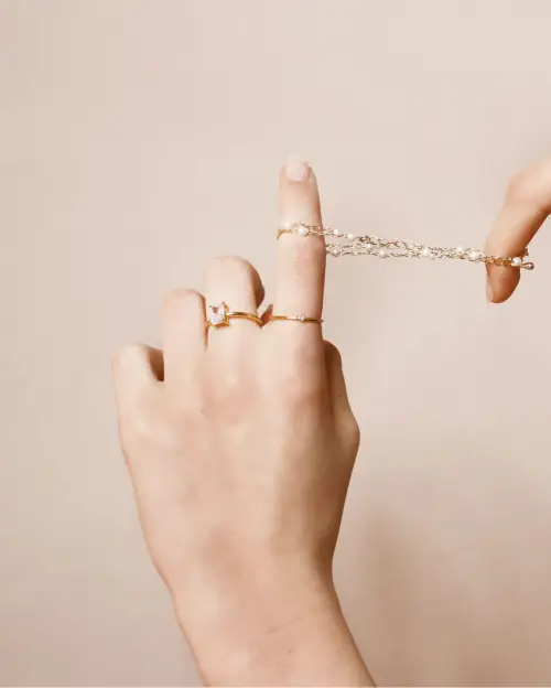 A person holding onto a chain with their finger.