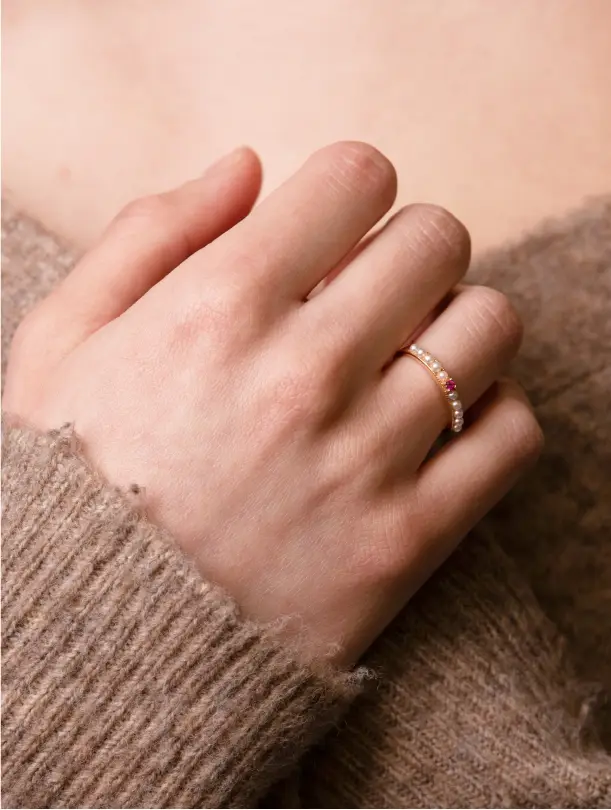 A person is holding their hand up to the side of her chest.