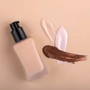 A bottle of liquid and some makeup on the table